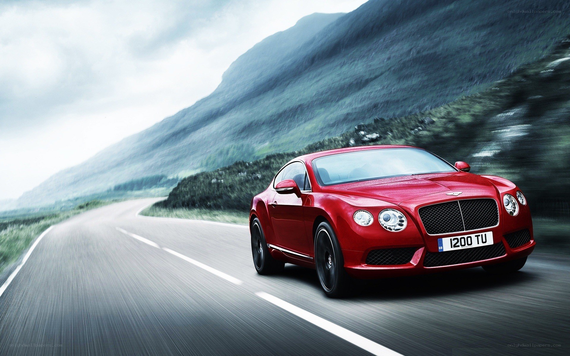 Red Bentley driving on mountain road