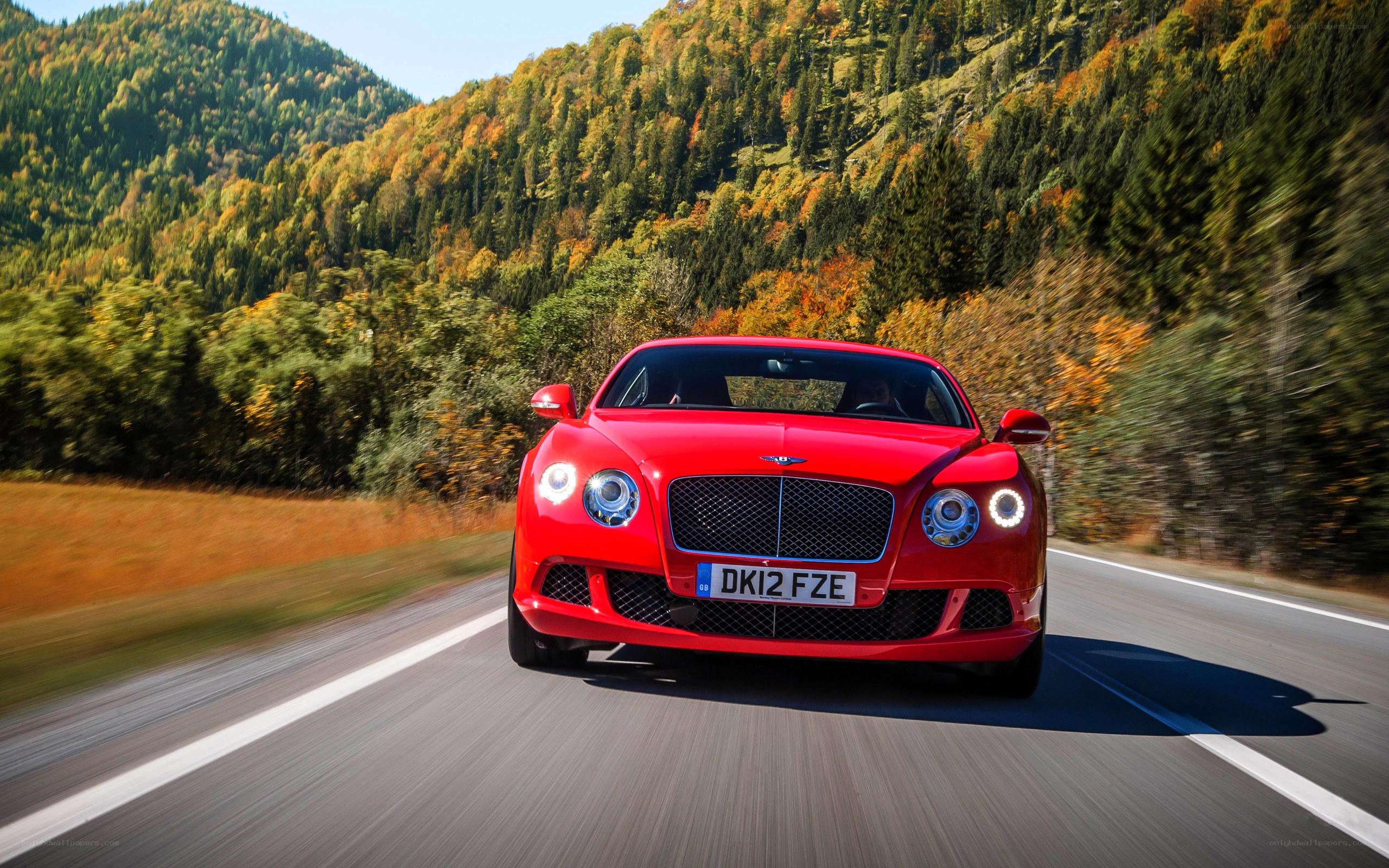 Red Bentley driving on mountain road