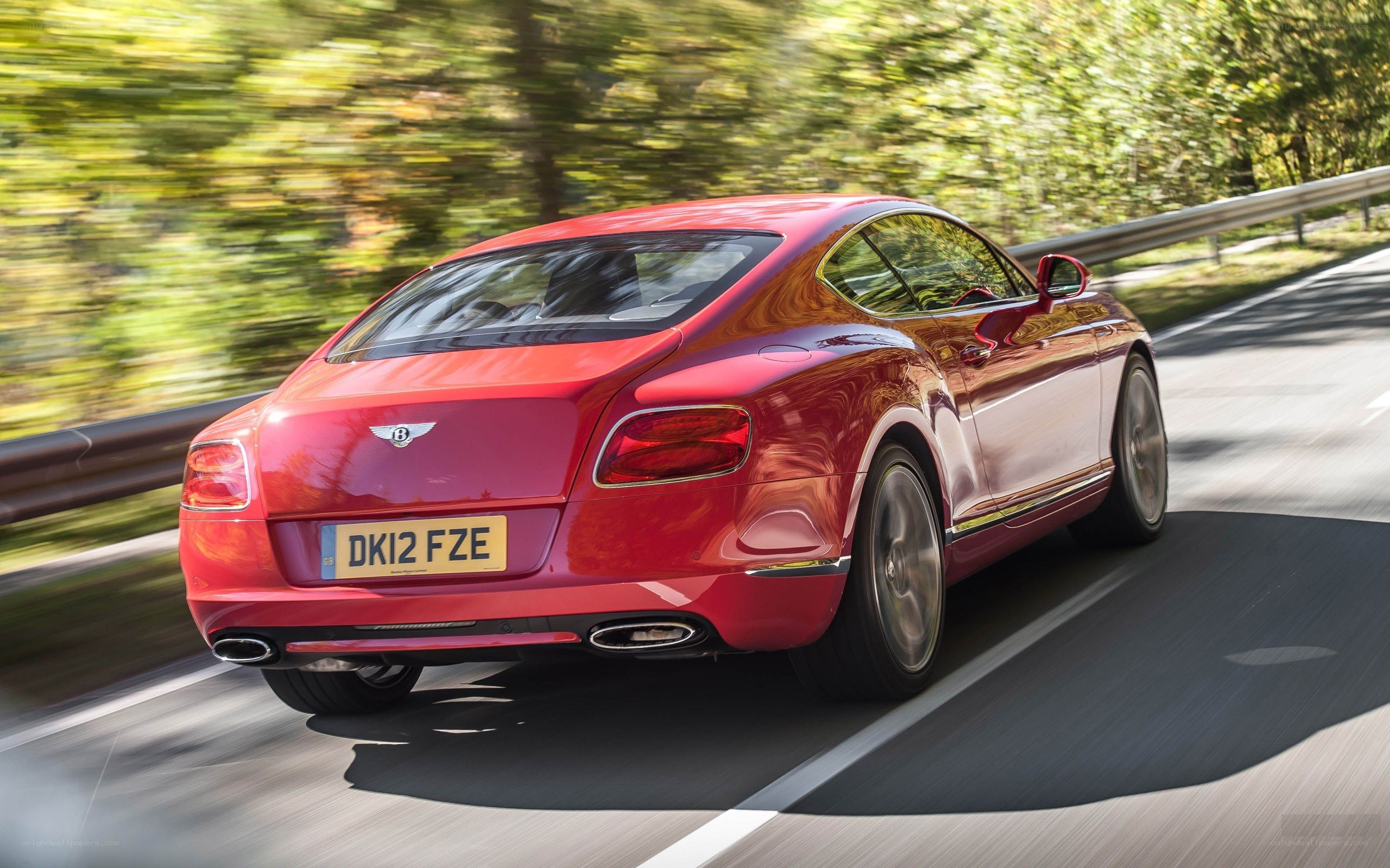 Red Bentley driving on road