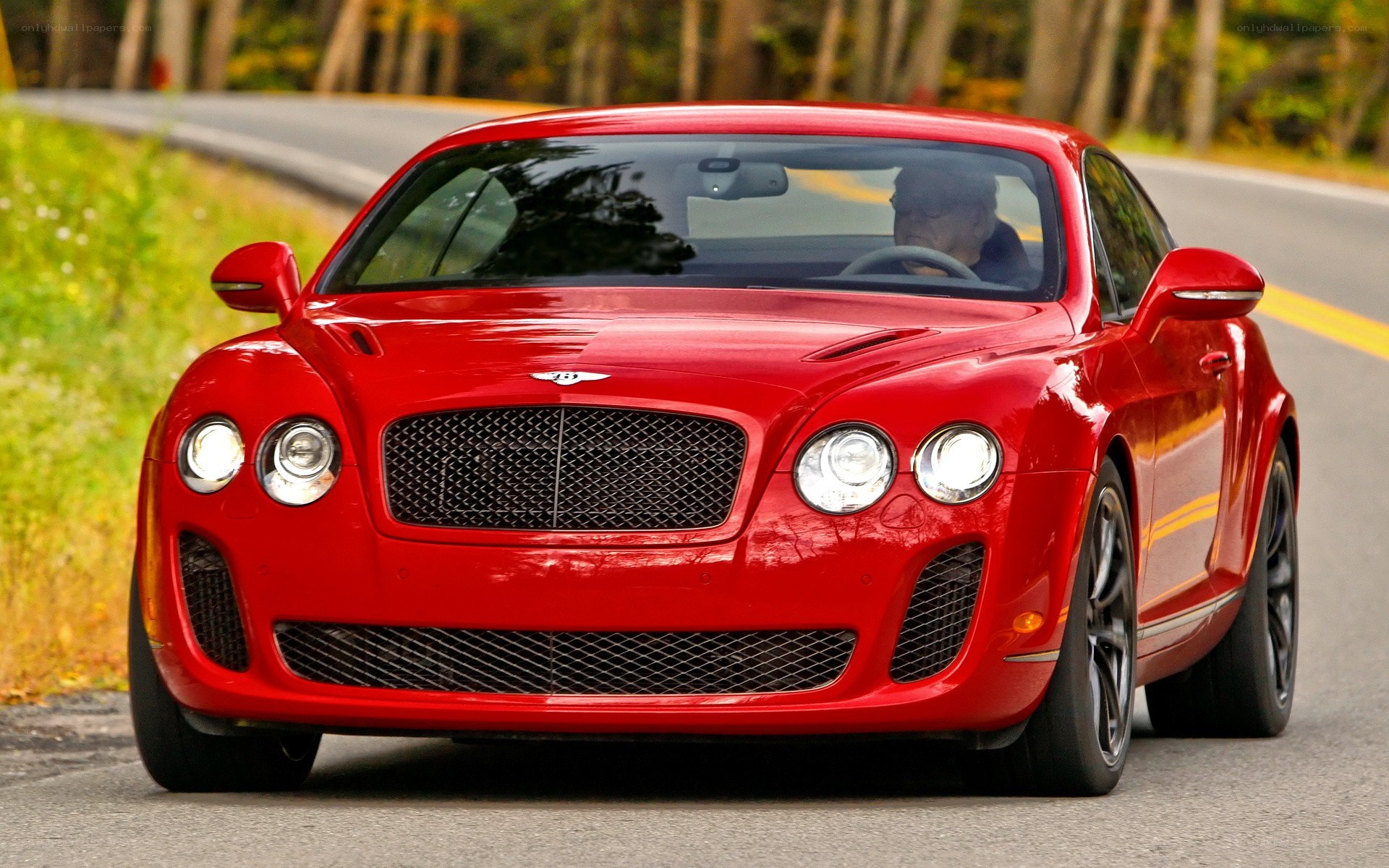 Red Bentley driving on road