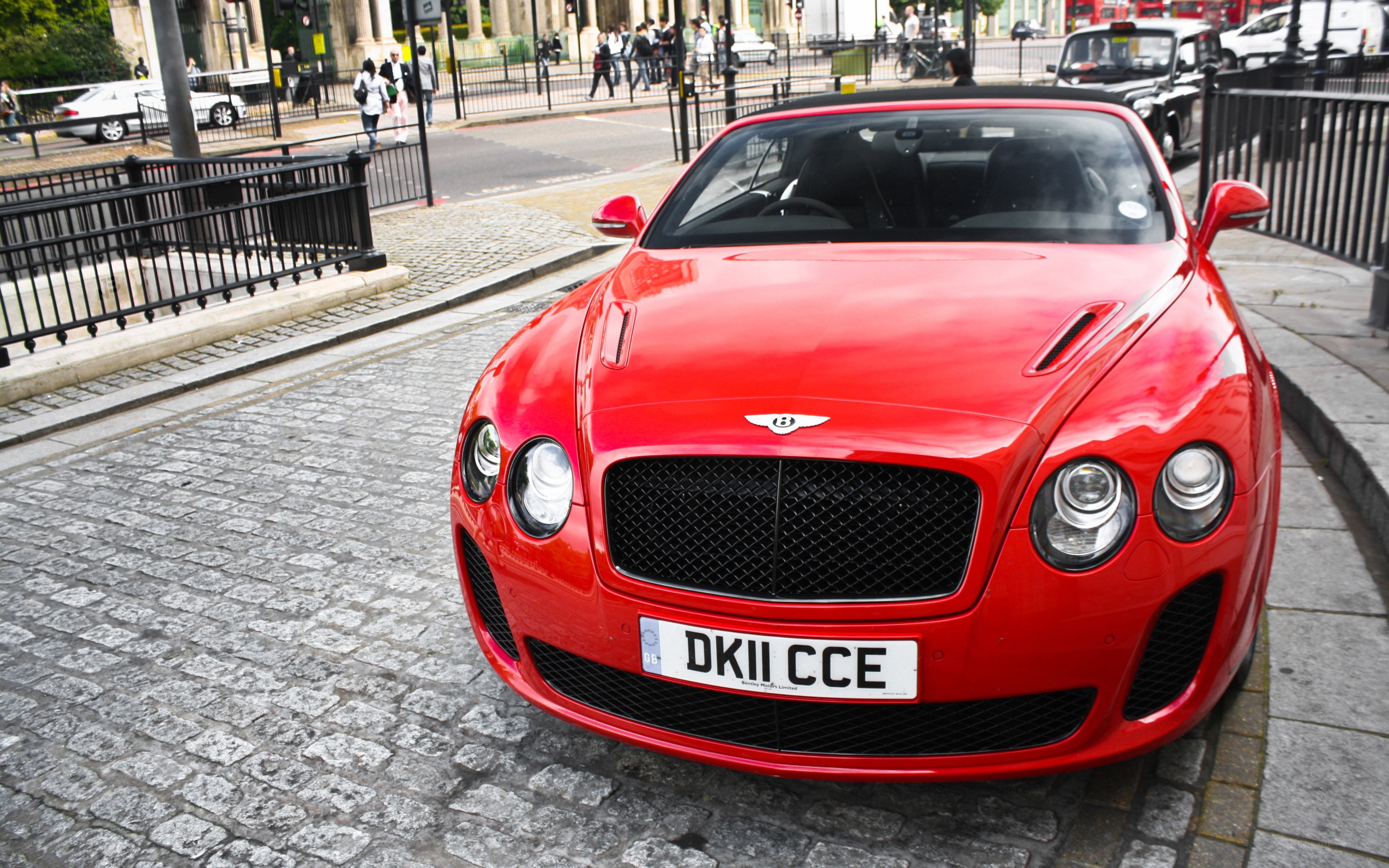 Red Bentley parked on cobblestones