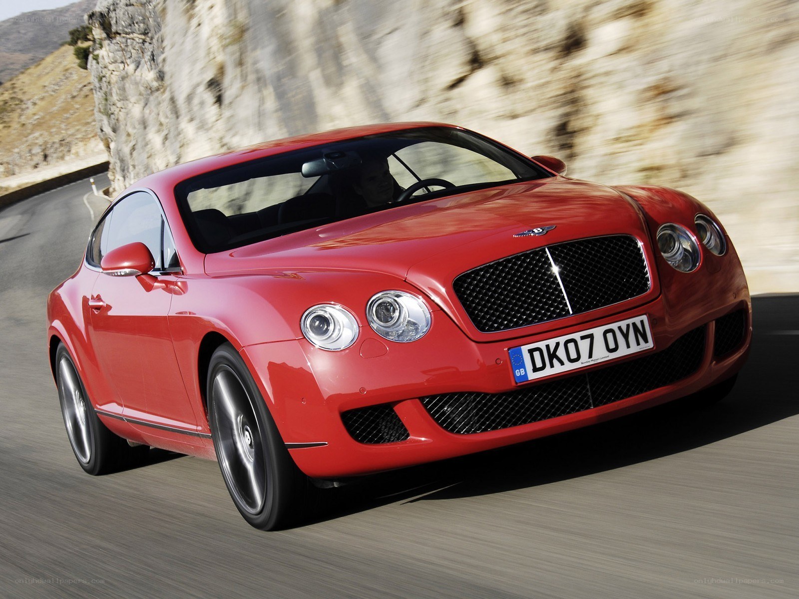 Red Bentley speeding on mountain road