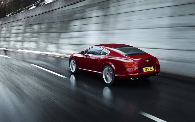 Red Bentley speeding on wet road
