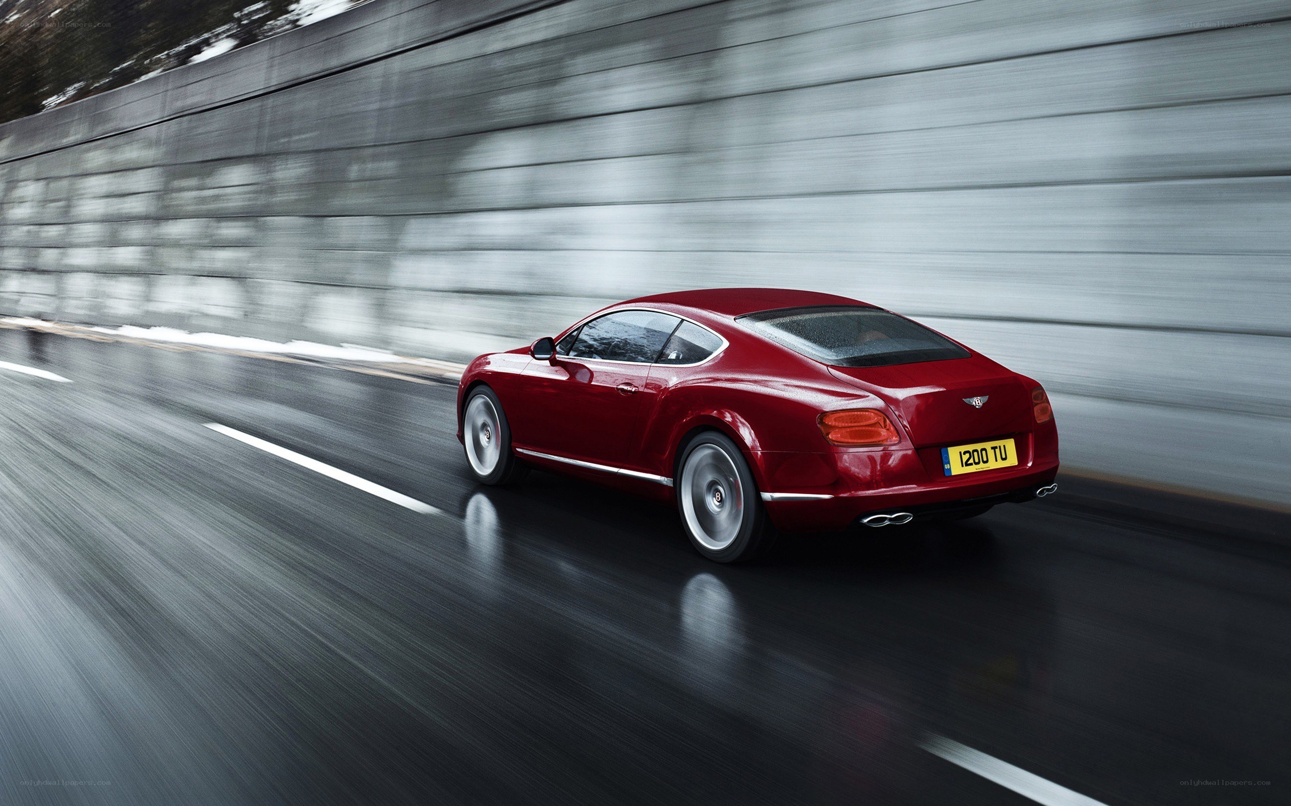 Red Bentley speeding on wet road