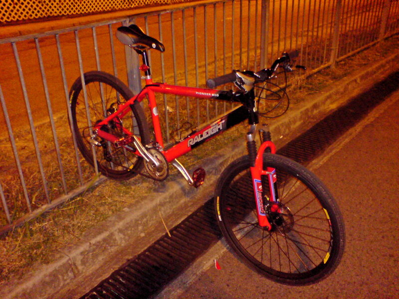 Red bicycle parked at night