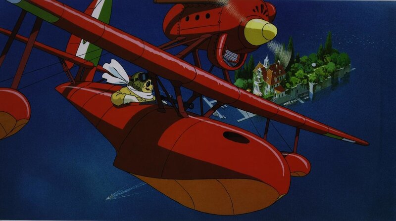 Red biplane flying over island