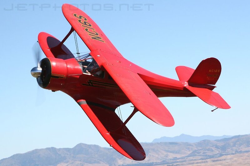 Red biplane in flight
