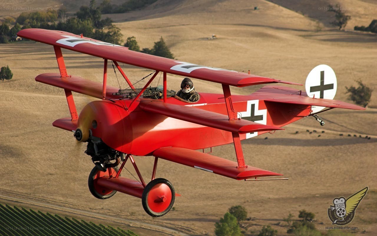 Red biplane in flight