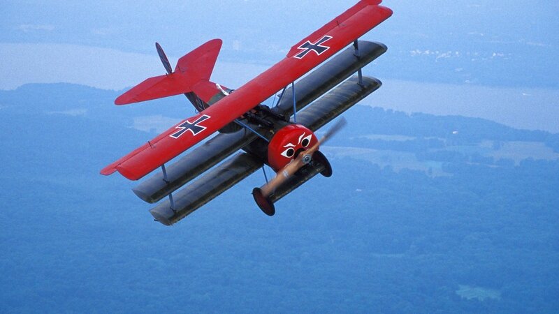 Red biplane in flight