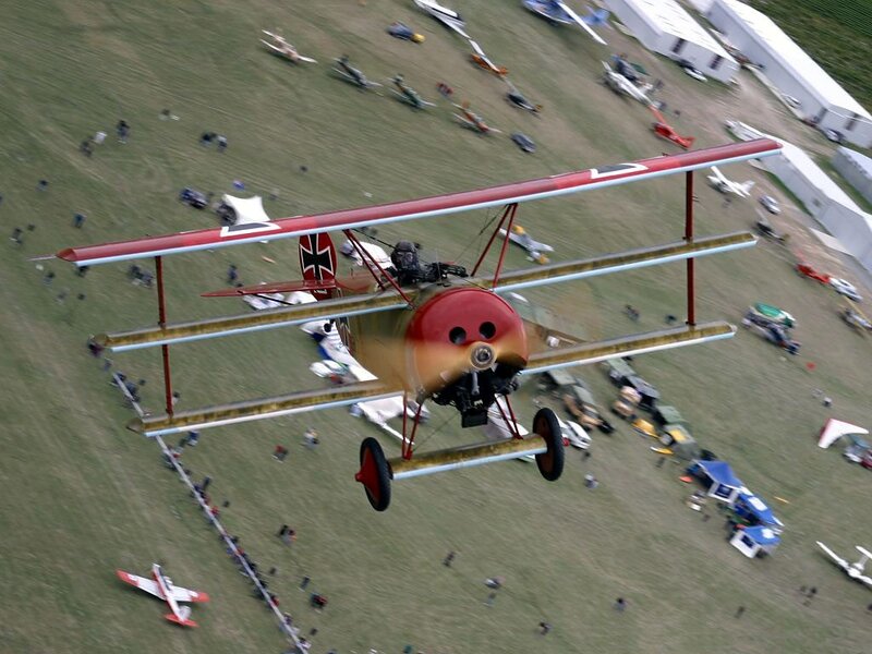 Red Biplane in Flight — Dynamic, Afternoon, Photograph, Airfield