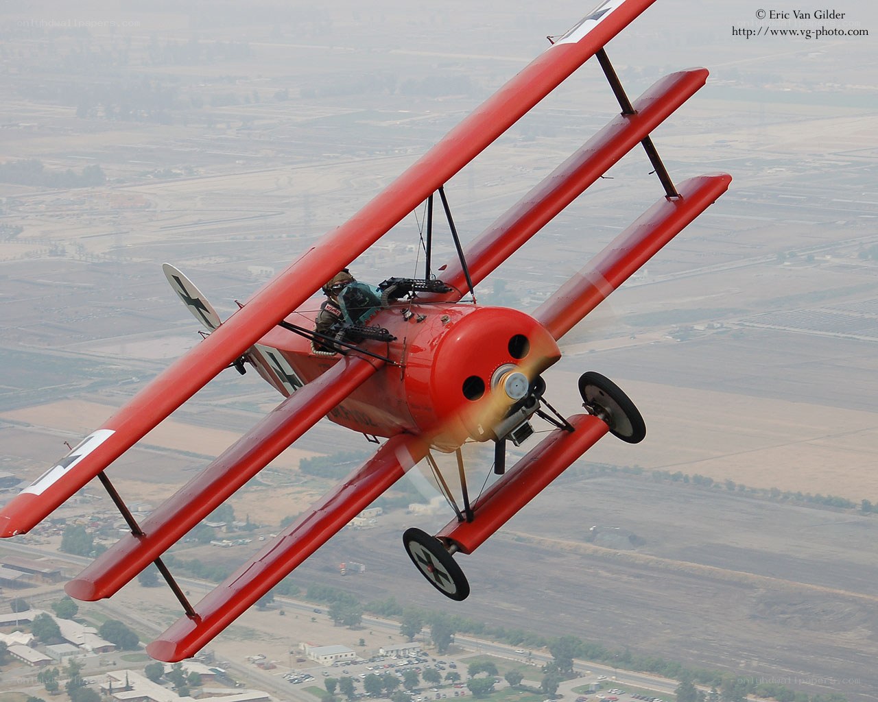 Red biplane in flight