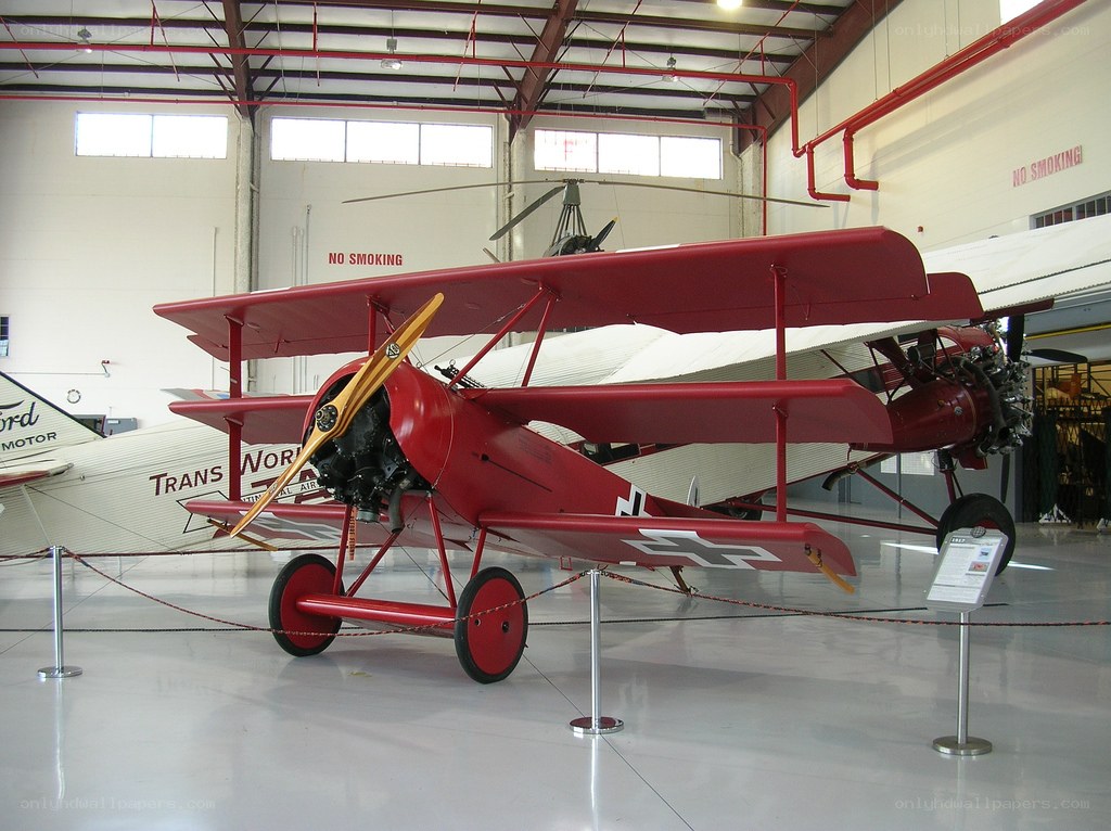 Red biplane in museum hangar