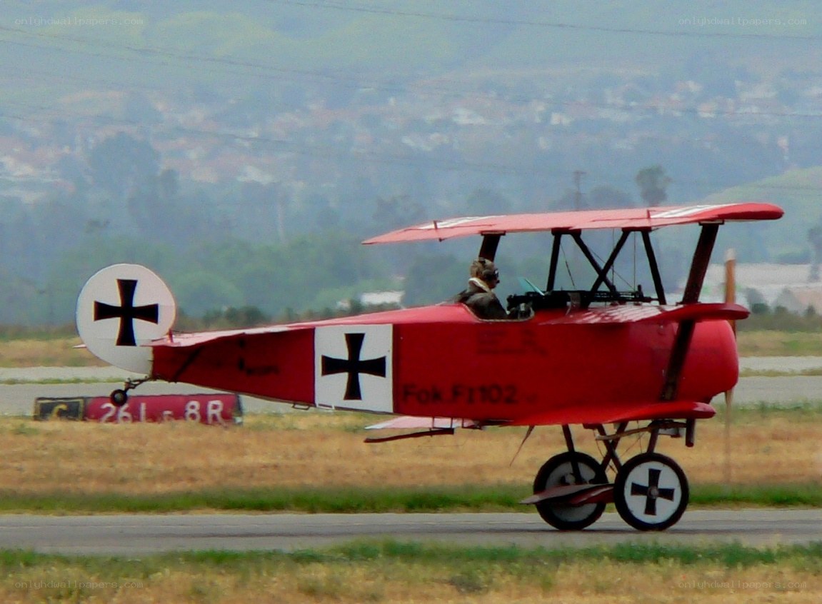 Red biplane on runway