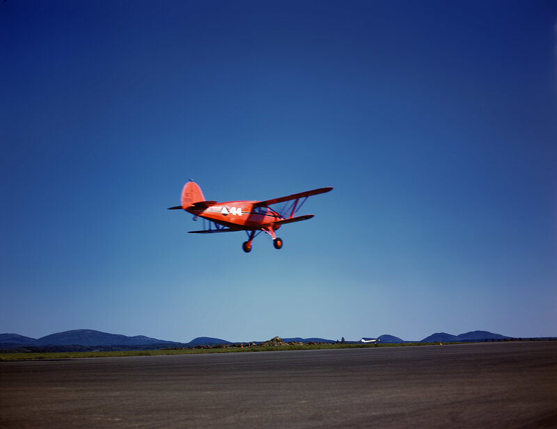 Red biplane taking off