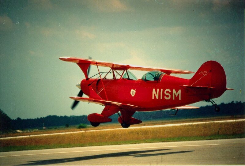 Red biplane taking off