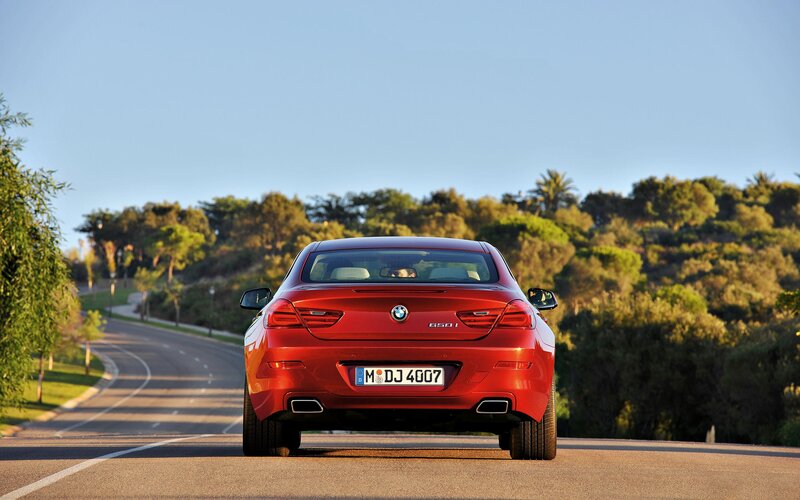 Red BMW 650i on a scenic road