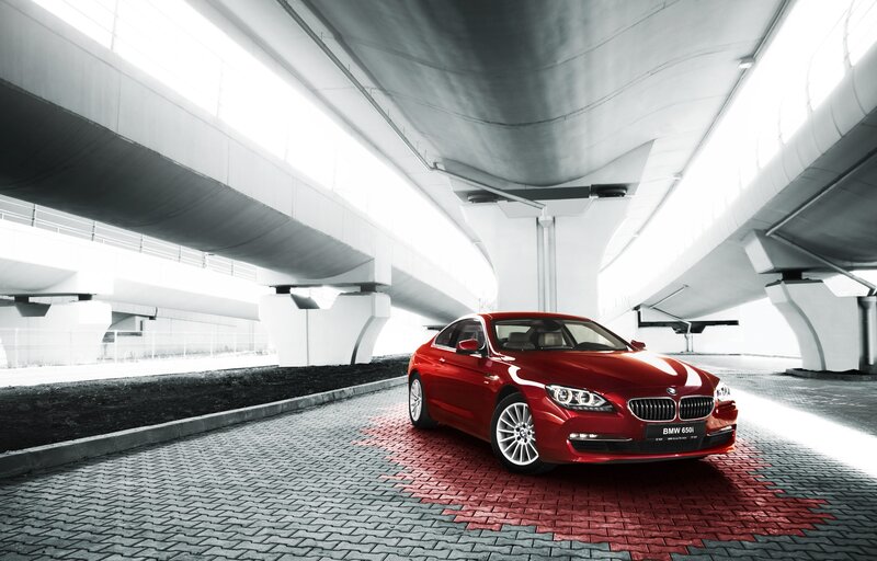 Red BMW 650i under overpass