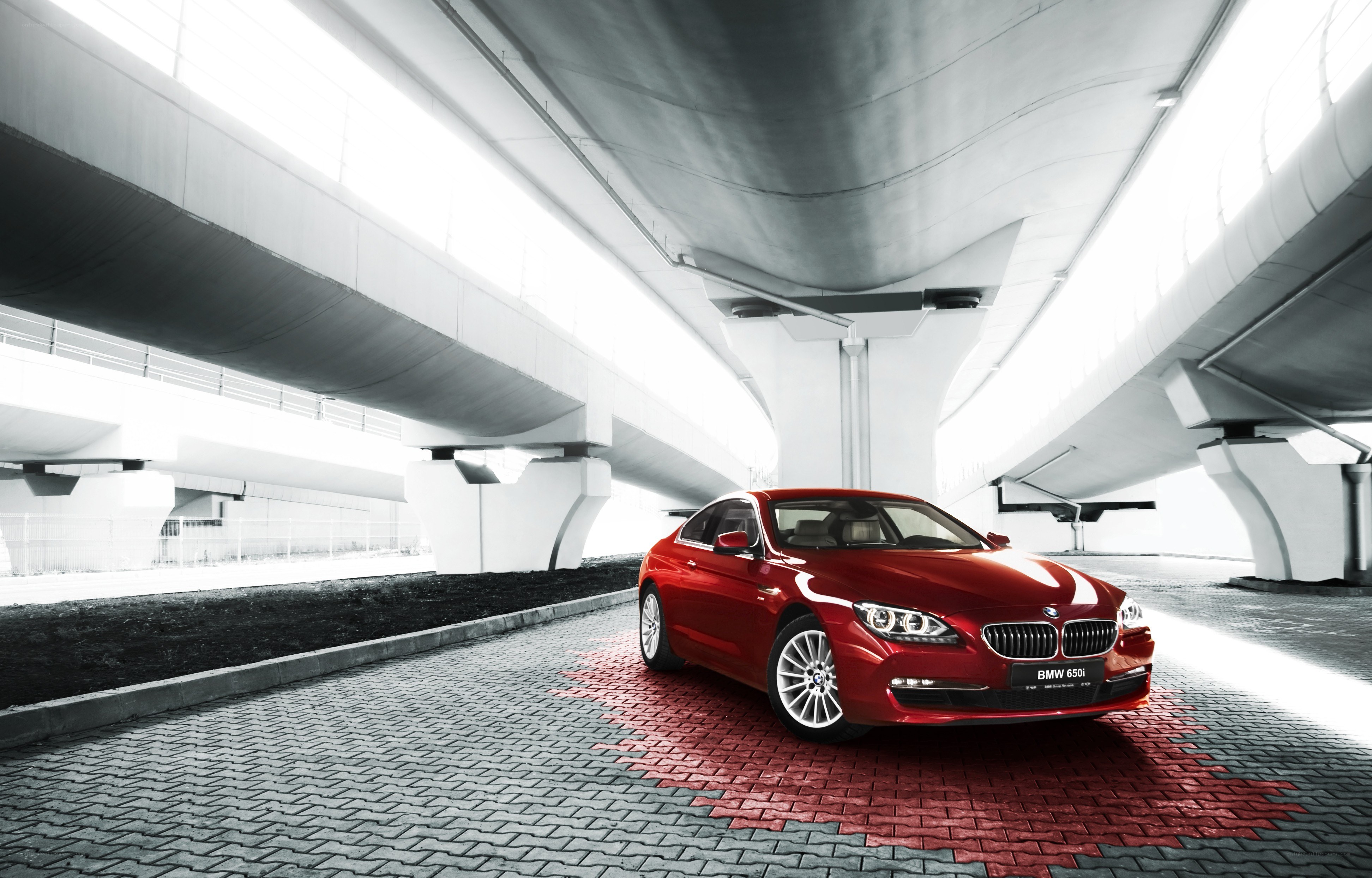 Red BMW 650i under overpass
