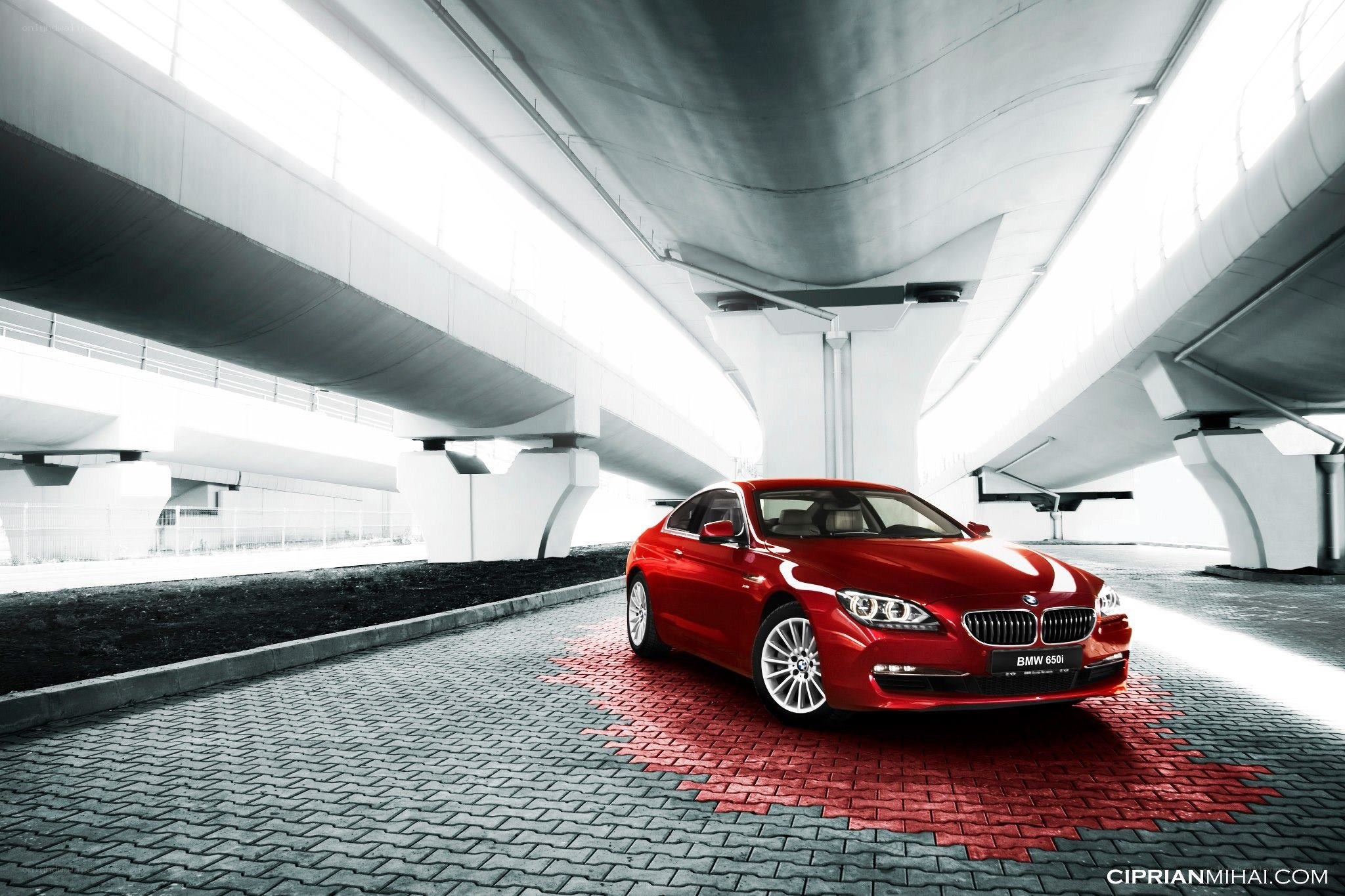 Red BMW 650i under overpass