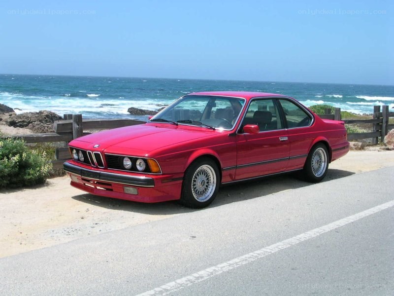 Red BMW coupe by the ocean