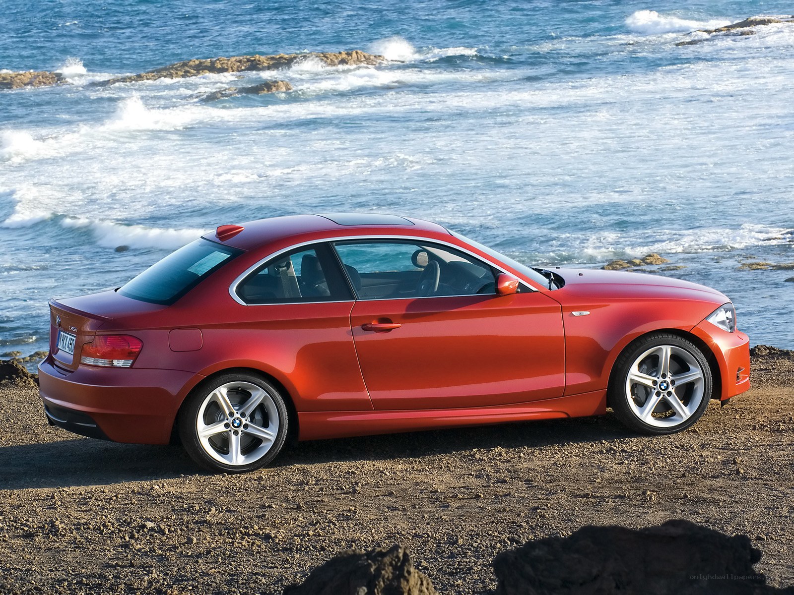Red BMW coupe by the sea