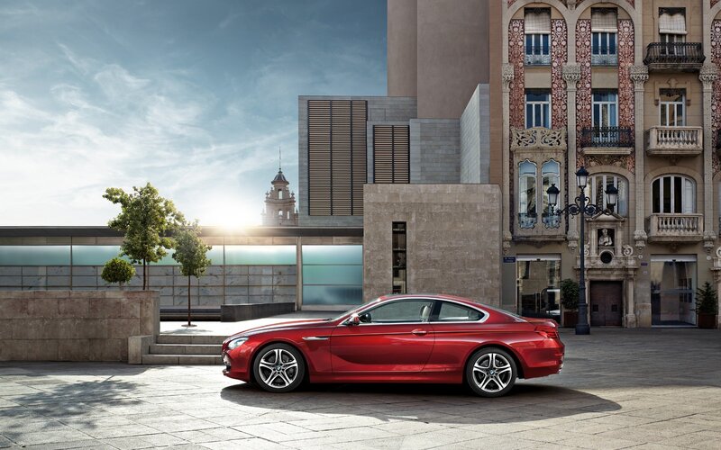 Red BMW coupe in city square