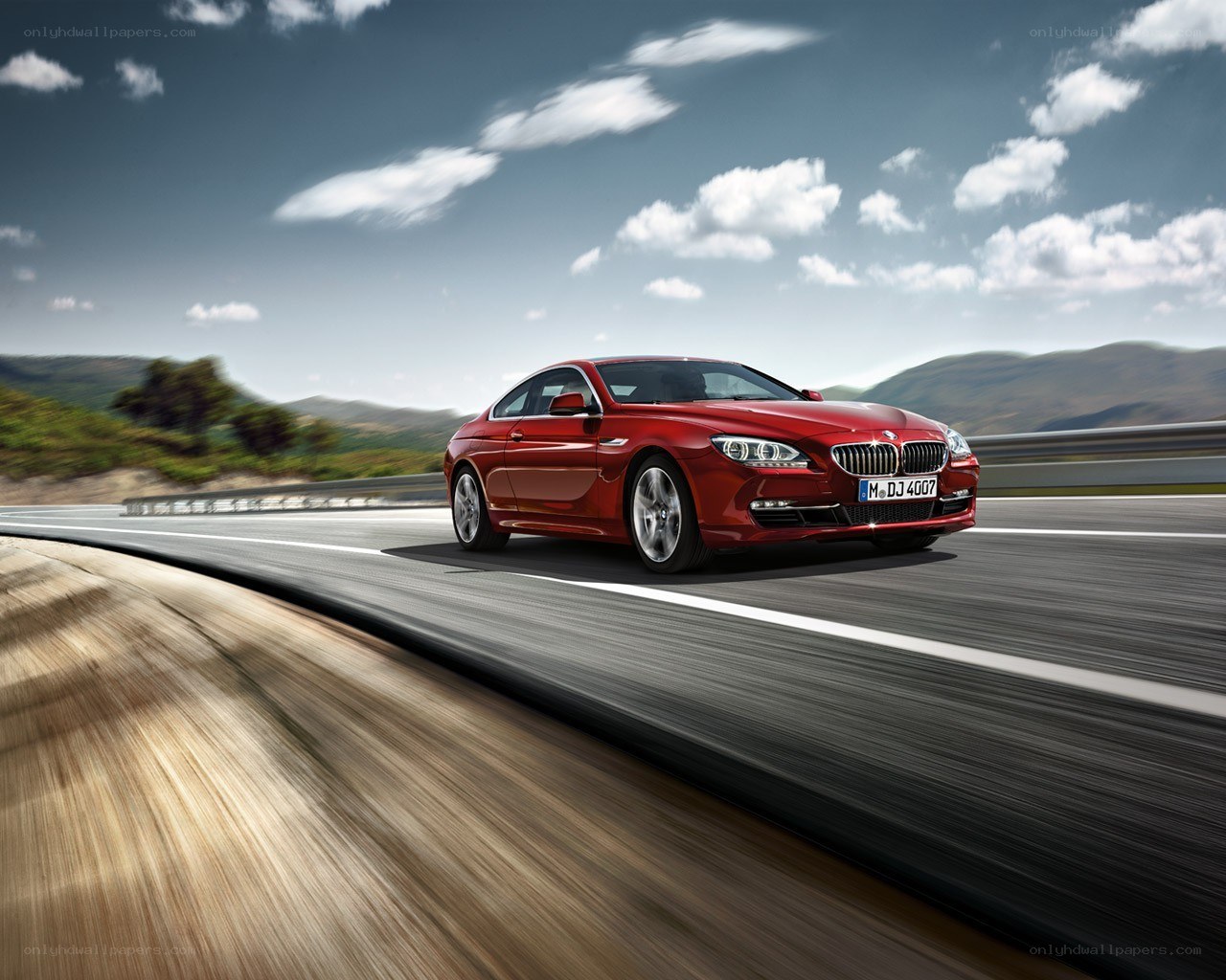 Red BMW coupe on a road