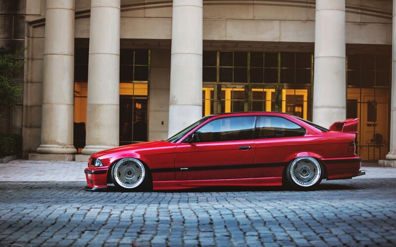 red bmw coupe on cobblestones