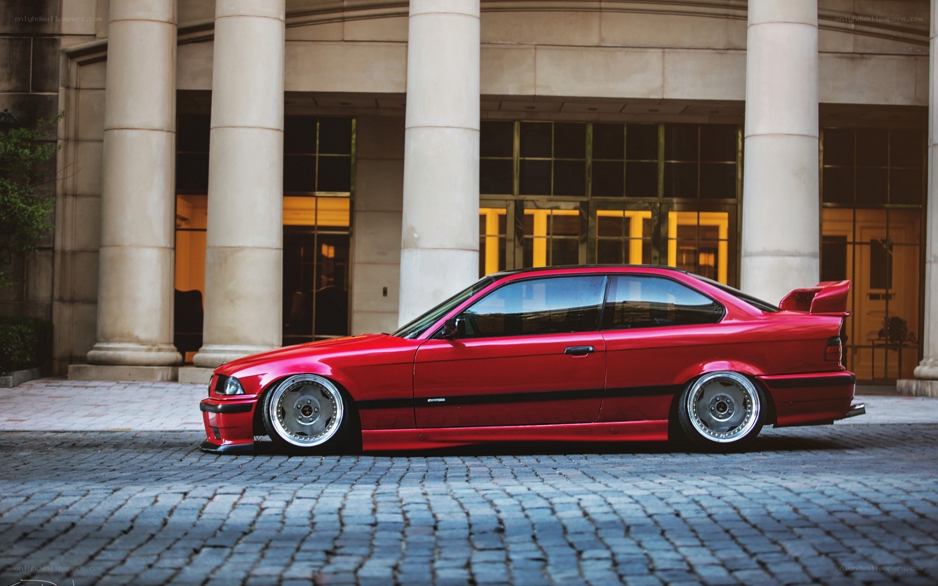 red bmw coupe on cobblestones