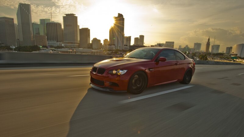 red bmw driving in city
