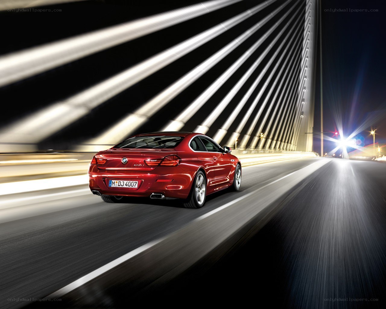 Red BMW driving on a bridge