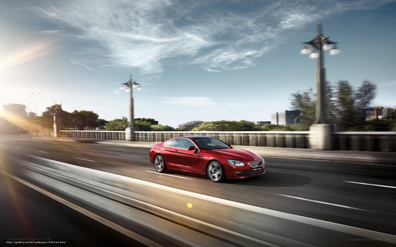 Red BMW driving on a bridge