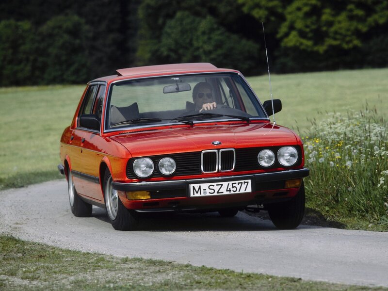 Red BMW driving on a country road