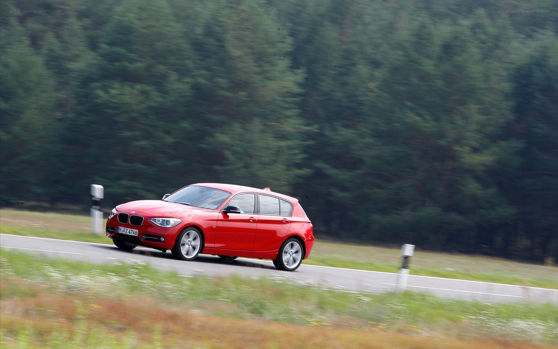 Red BMW driving on a road
