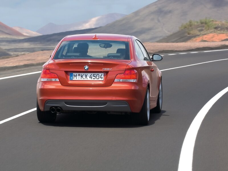 Red BMW driving on a road