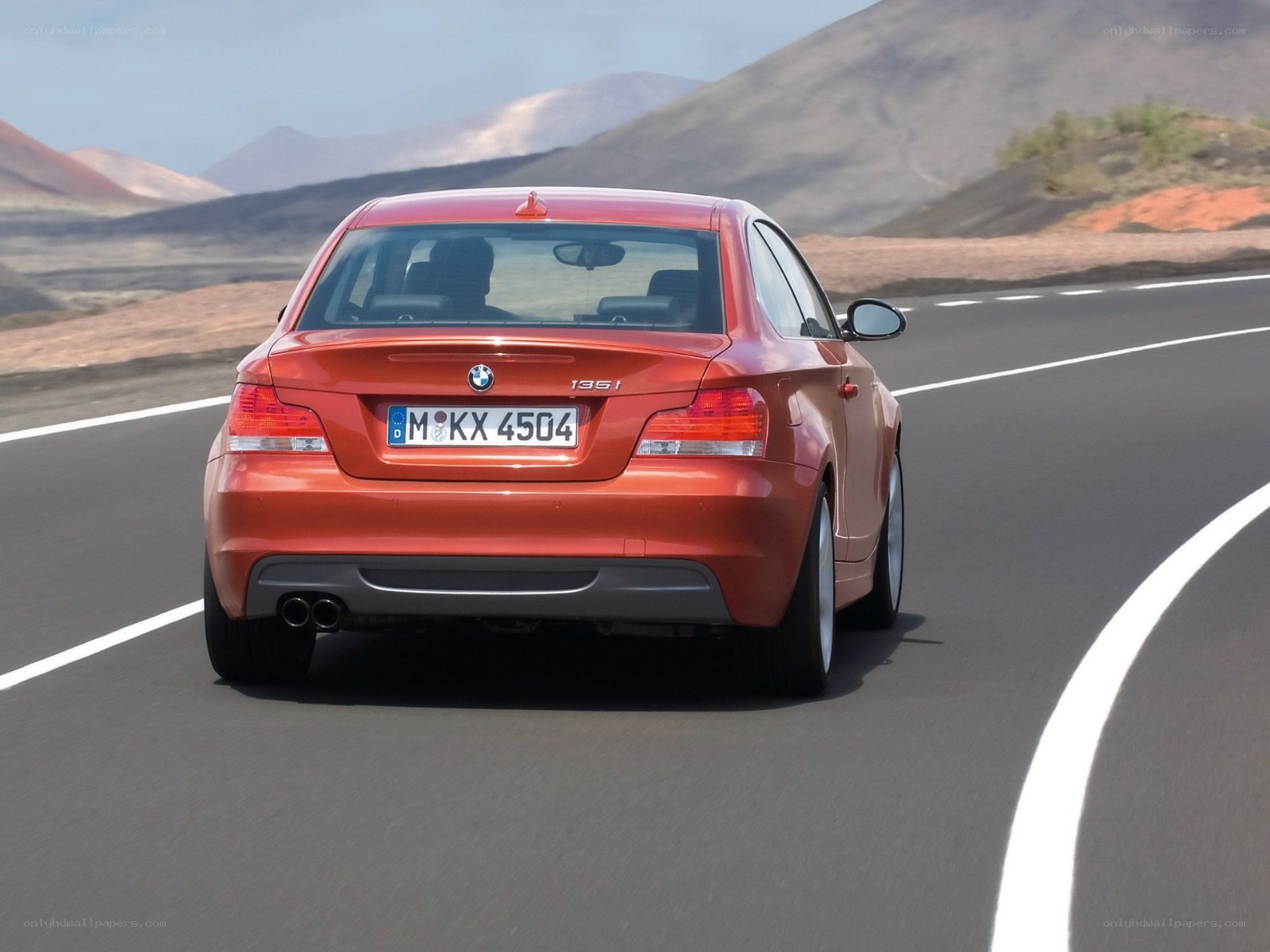 Red BMW driving on a road