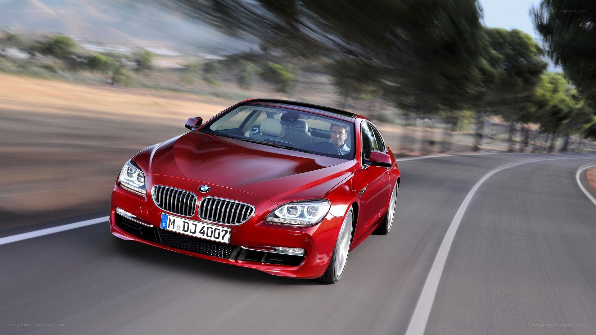 Red BMW driving on a road