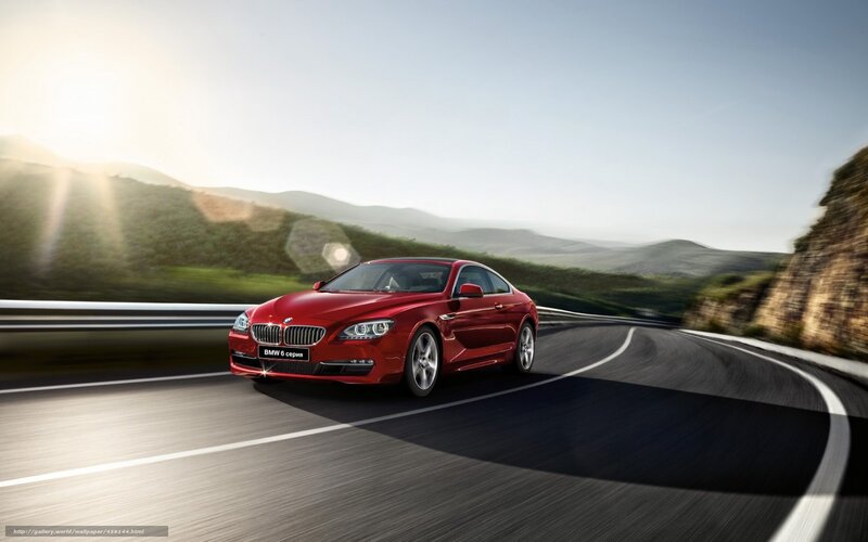 Red BMW driving on a winding road
