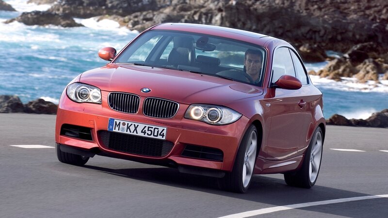 Red BMW driving on coastal road