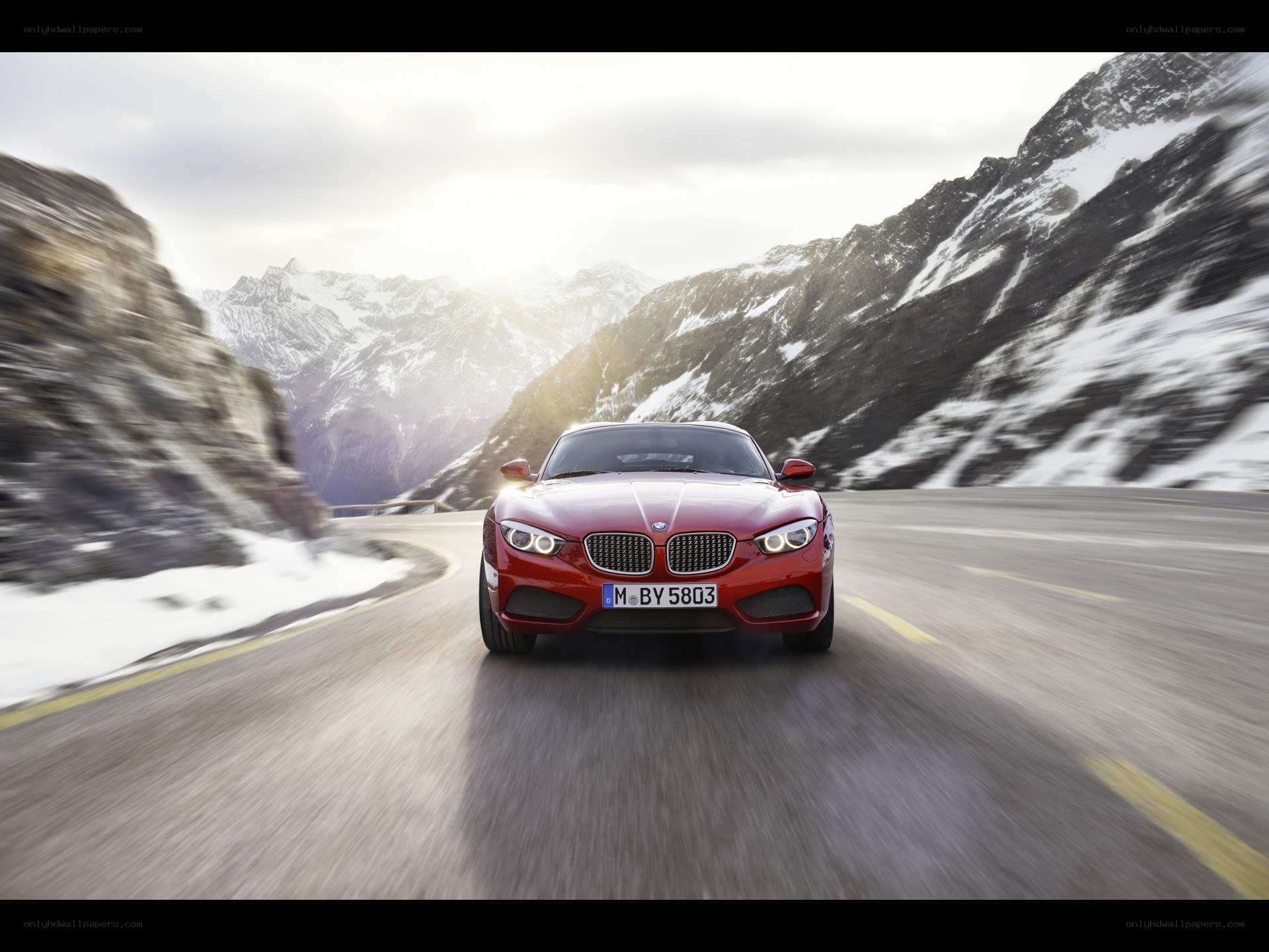 Red BMW driving on mountain road