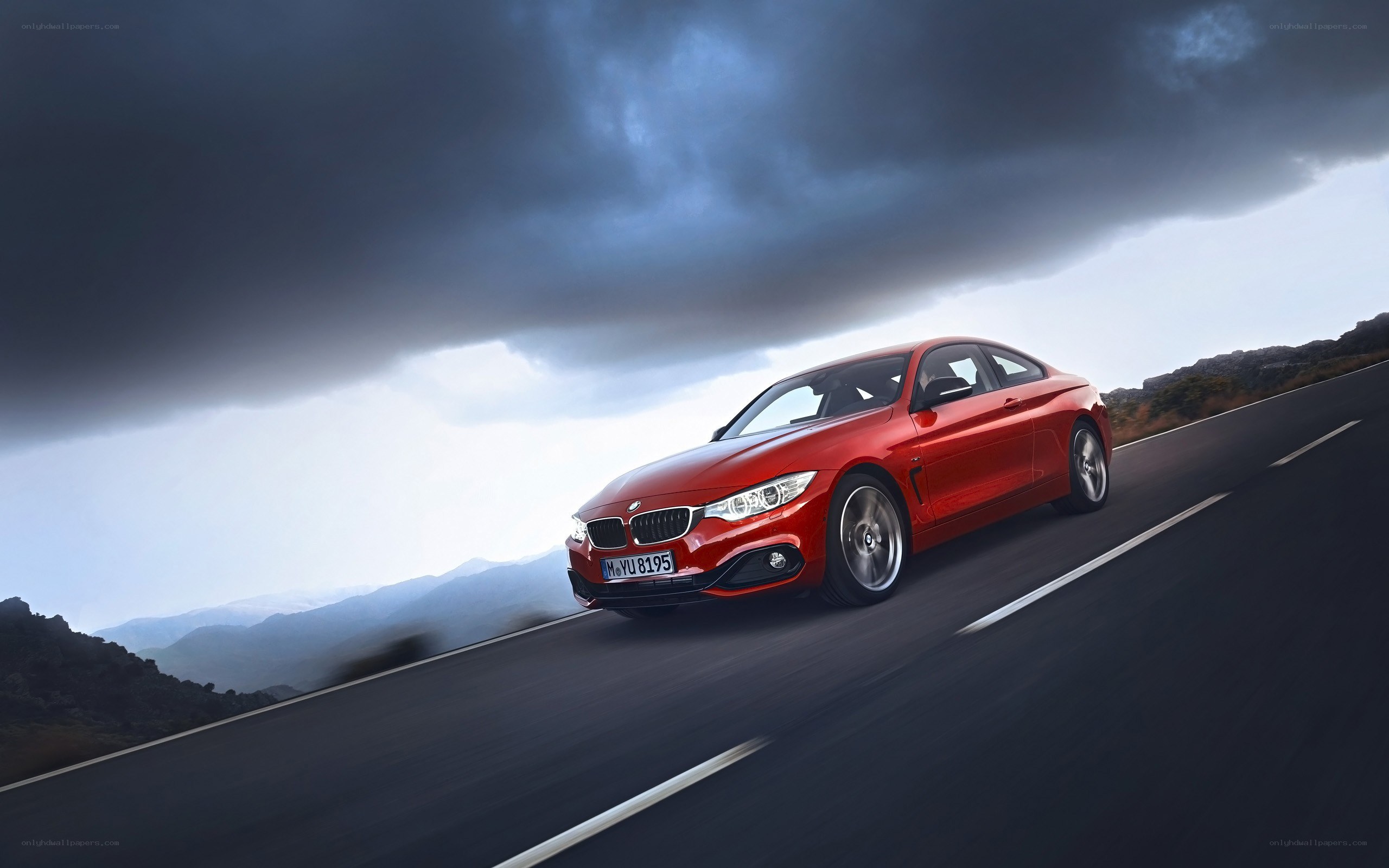 Red BMW driving on mountain road