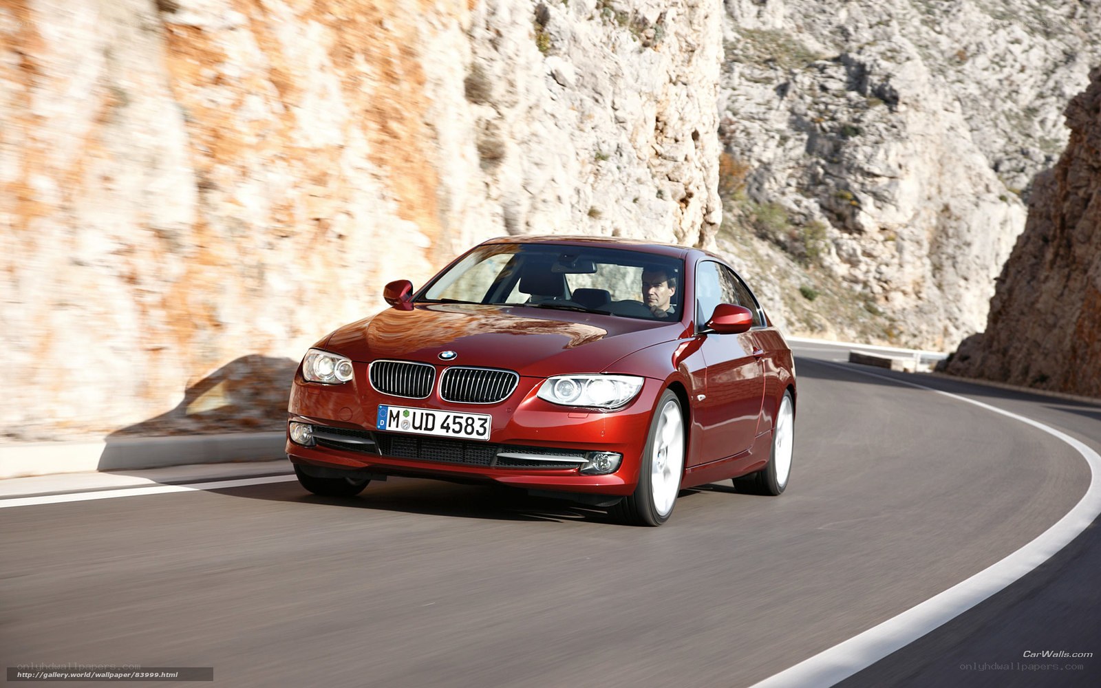 Red BMW driving on mountain road