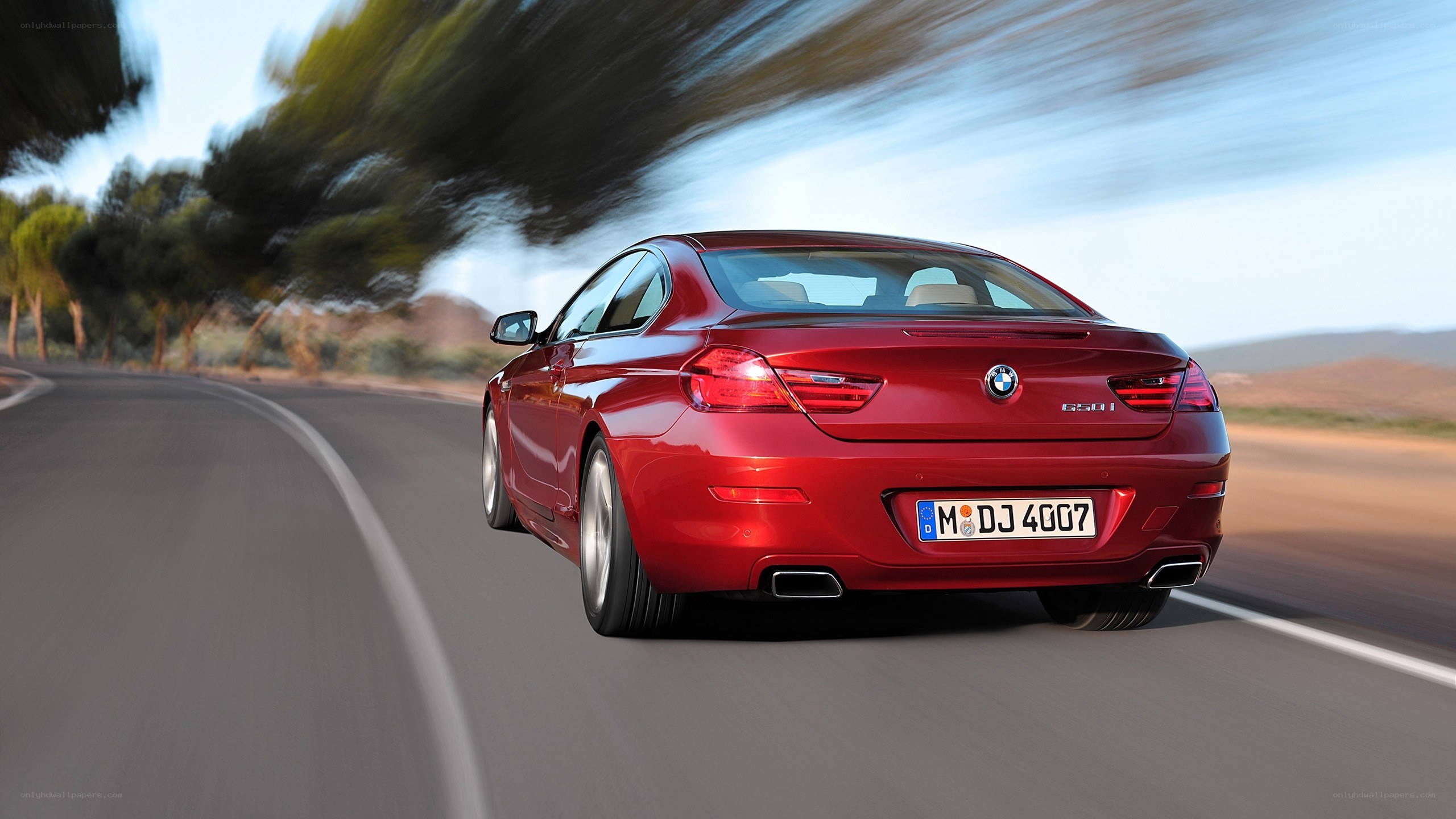 Red BMW driving on road