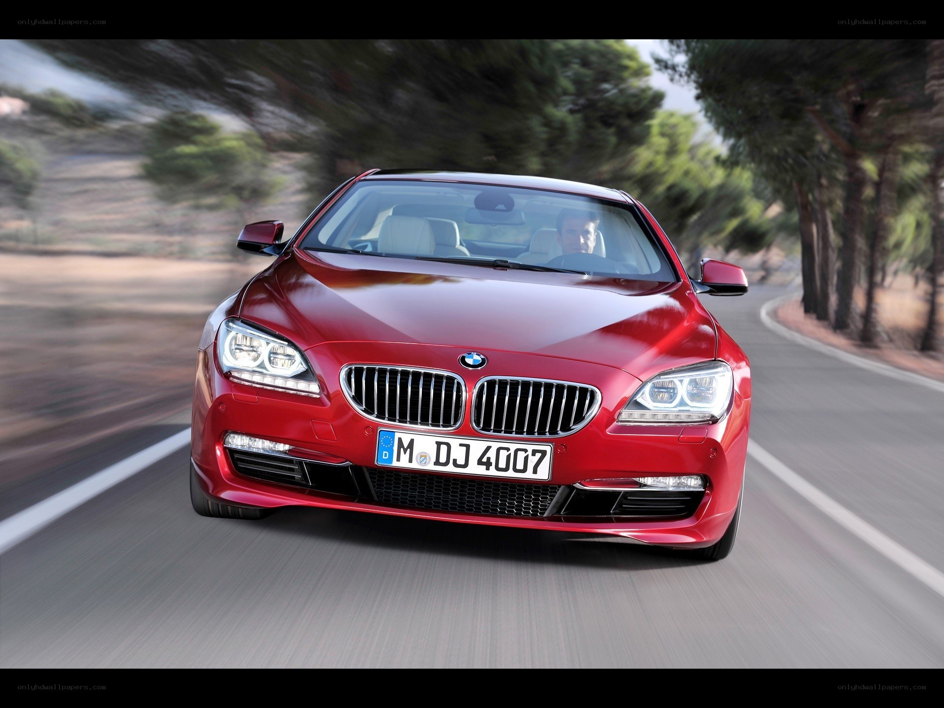 Red BMW driving on road