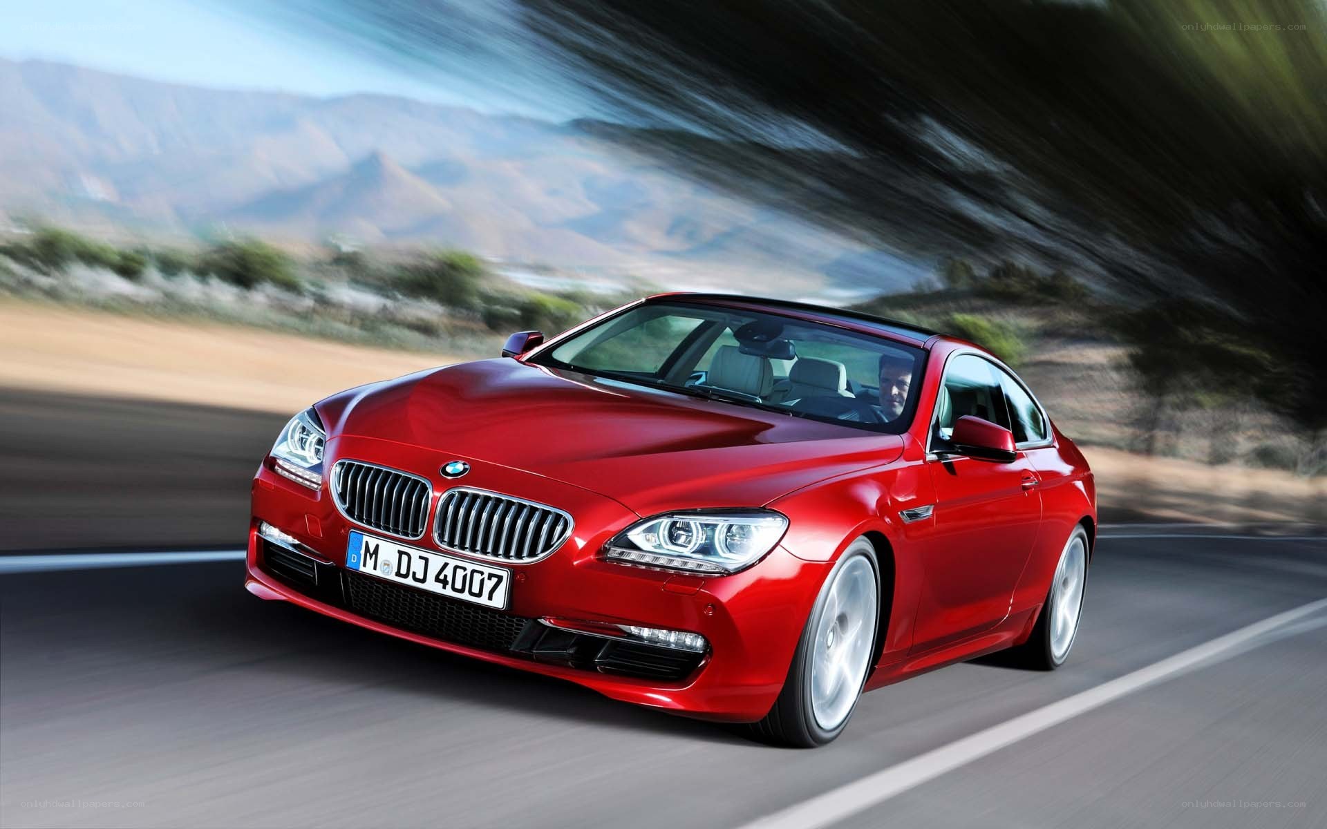 Red BMW driving on road