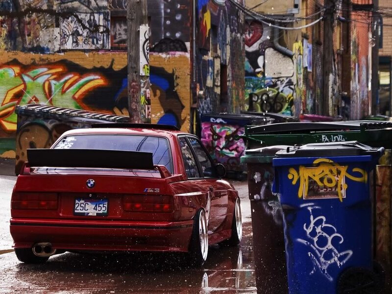 Red BMW in a graffiti alley