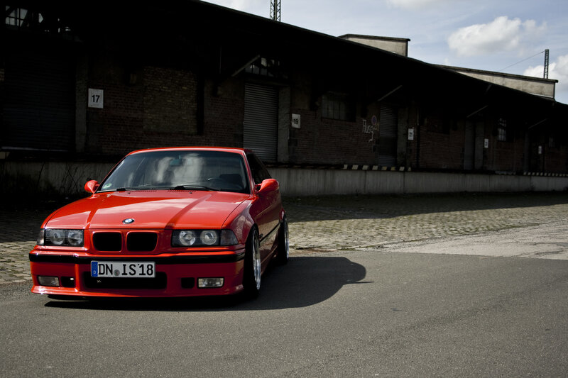Red BMW in an industrial lot