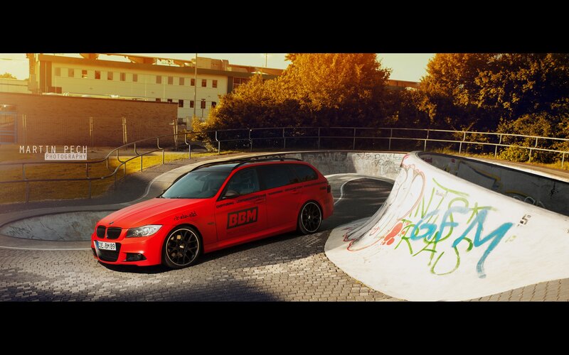 Red BMW in skatepark at sunset
