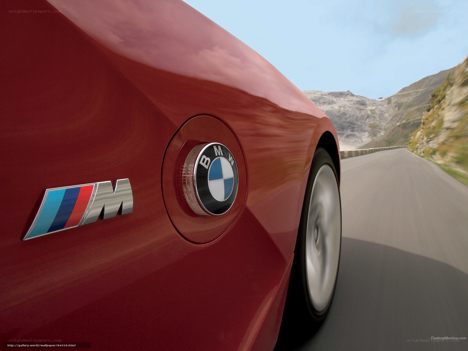 Red BMW M car on mountain road