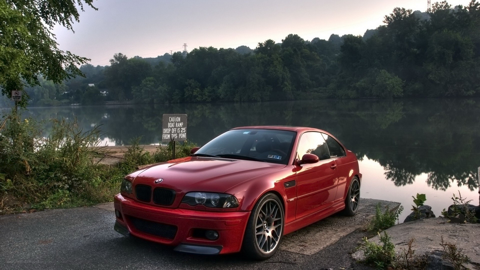 Red BMW M3 by a lake